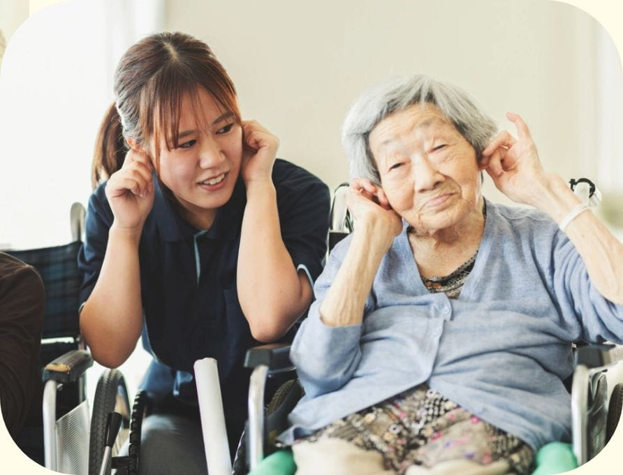 車椅子の高齢の患者さまと笑い合うスタッフ